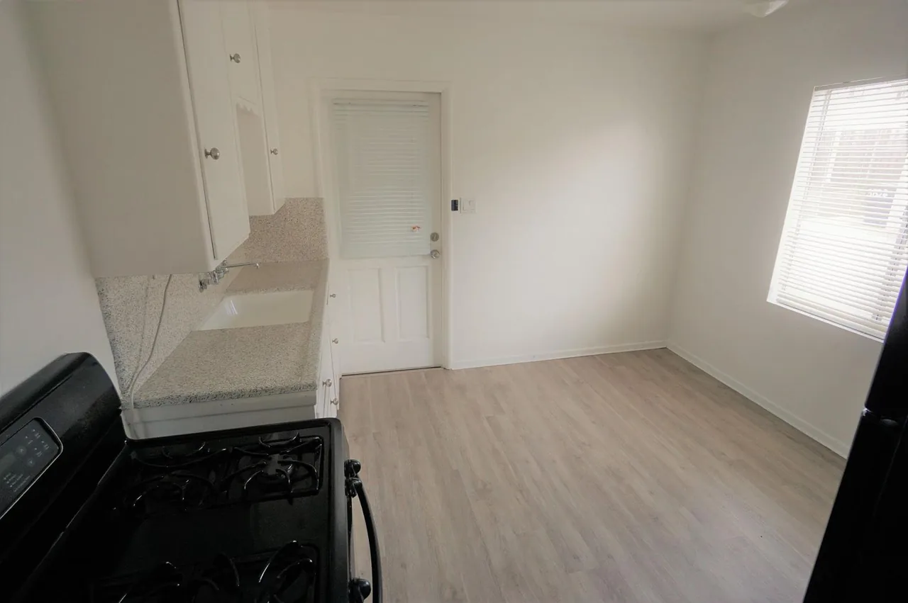 Kitchen with white cabinetry and bright window