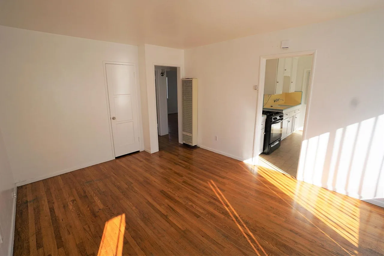 Open living and dining area with hardwood-style floors